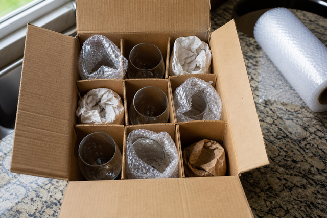 Wine glasses standing upright in a cardboard dish-pack with cell dividers